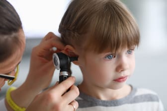 Ohrenärztin untersucht das Ohr eines Kindes