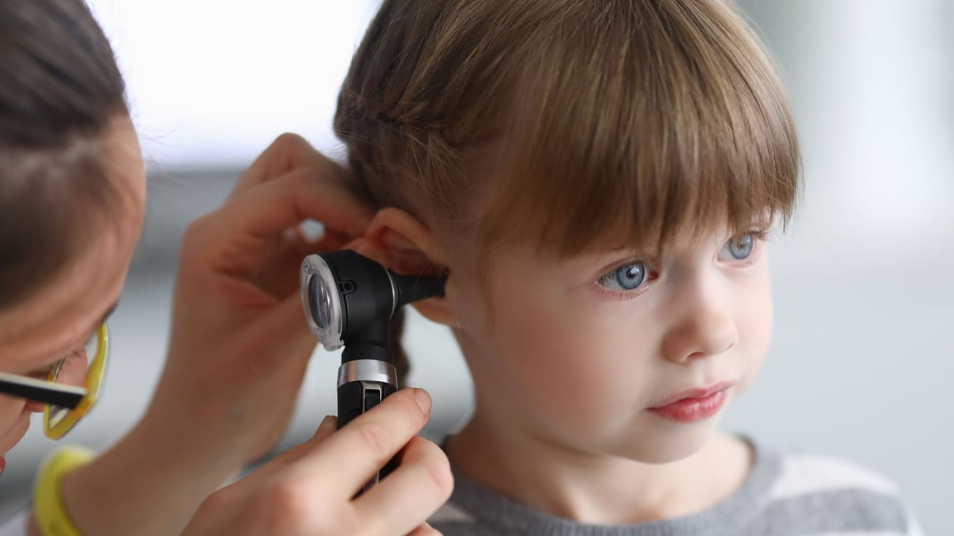 Ohrenärztin untersucht das Ohr eines Kindes