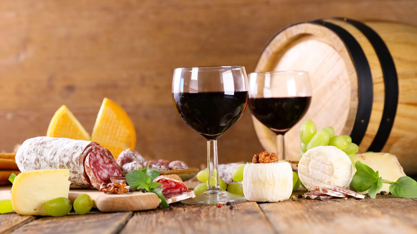 Käse, Salami, Rotwein und Weintrauben
