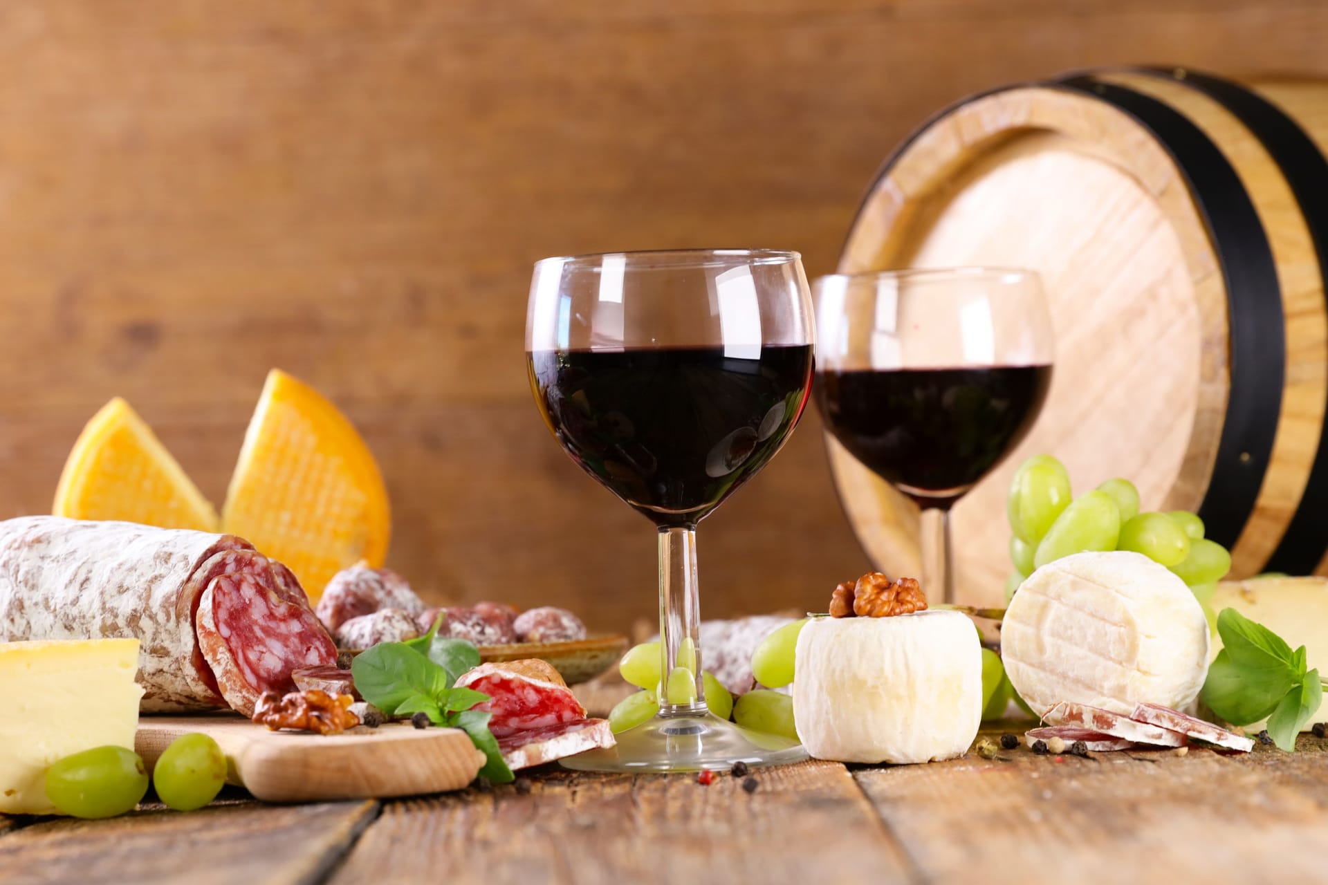 Käse, Salami, Rotwein und Weintrauben