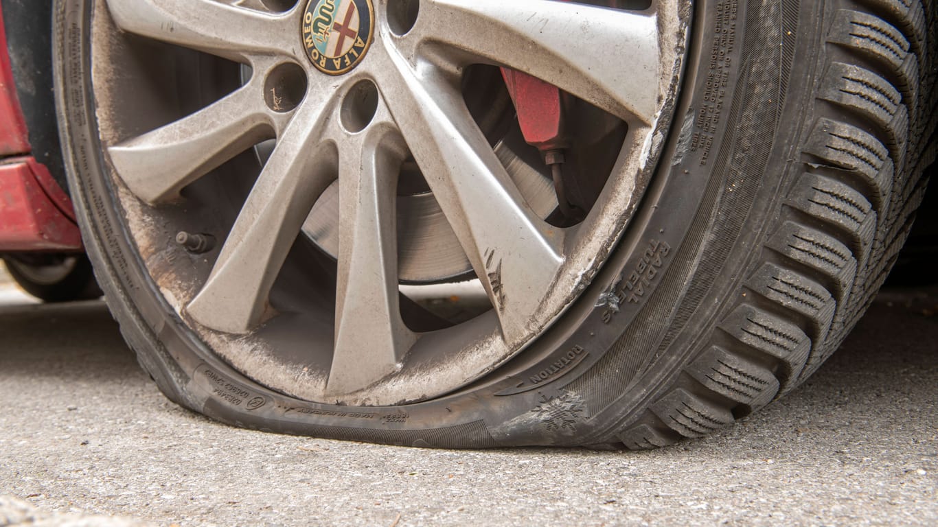 Ein platter Autoreifen (Symbolbild): Ein Mann hat mindestens an zwölf Fahrzeugen die Reifen zerstochen.