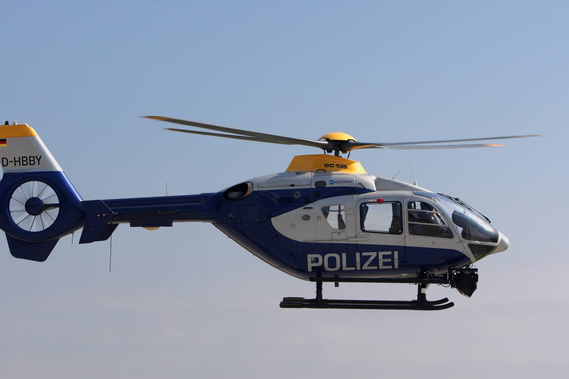 Ein Polizeihubschrauber im Flug (Symbolbild): Die Fahndungsmaßnahmen nach dem Flüchtigen wurden am Wochenende fortgesetzt.