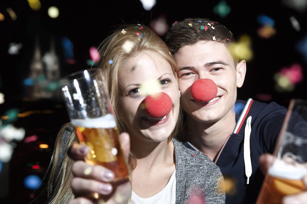 Zwei Jecken halten Kölschgläser in der Hand (Symbolbild): An Karneval steigen die Kölschpreise.