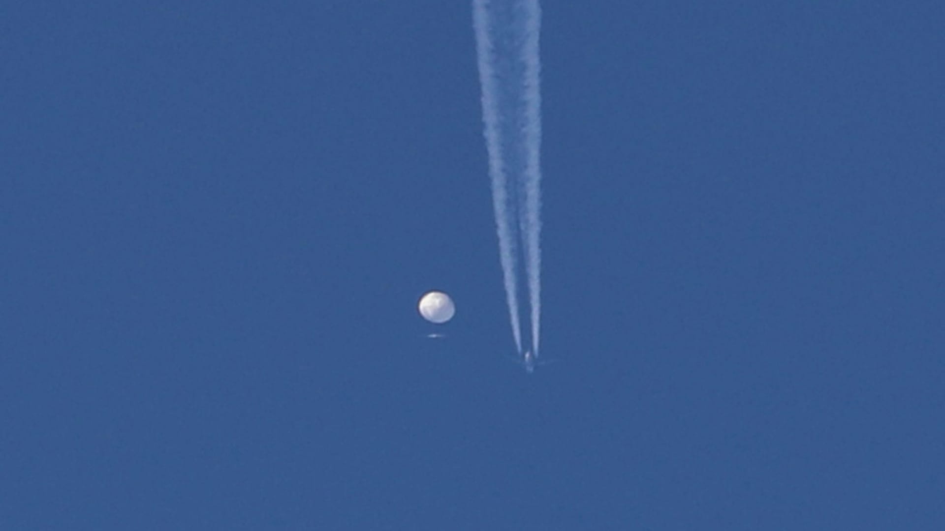 Kondensstreifen sind neben dem Ballon aus China zu sehen, bevor er abgeschossen wurde.