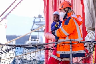Eine Helferin trägt ein kleines Kind im Hafen von Neapel an Land: Die Zahl derjenigen, die Europa über das Mittelmeer erreichen, steigt nach der Corona-Pause wieder an.
