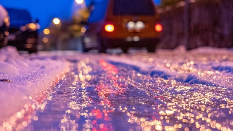 Eine dünne Eisschicht überzieht eine Straße (Symbolfoto): In Holstein kann es nachts knackig kalt werden.
