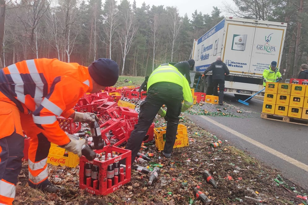 Ein Lastwagen hat am Montagmorgen seine Cola-Lieferung verloren: Mitarbeiter der Getränkefirma halfen beim Aufräumen.