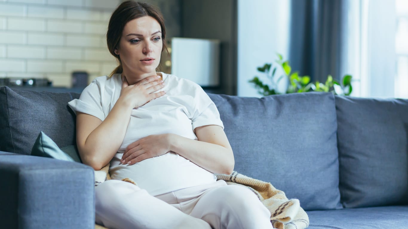 Pregnant woman with nausea on the couch