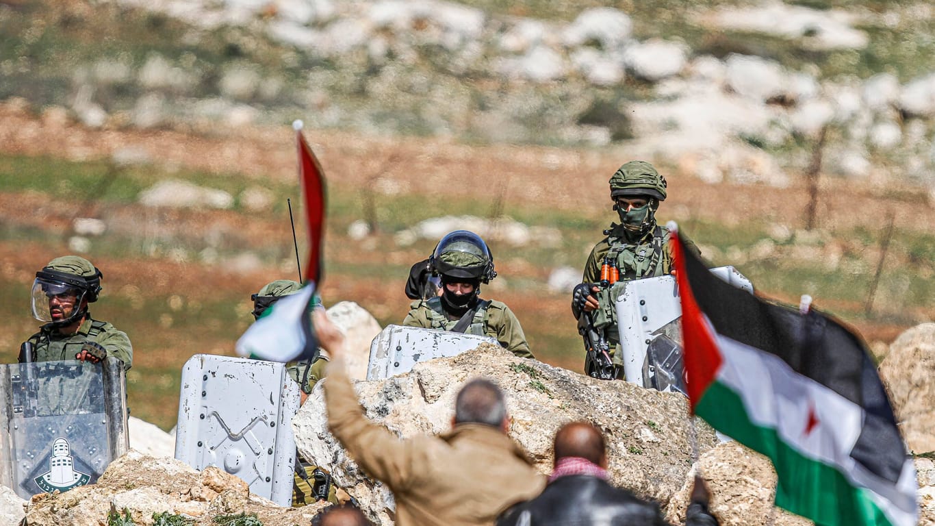 Nablus, Westjordanland (Archivbild): Palästinensische Demonstranten schwenken palästinensische Flaggen vor den israelischen Soldaten.