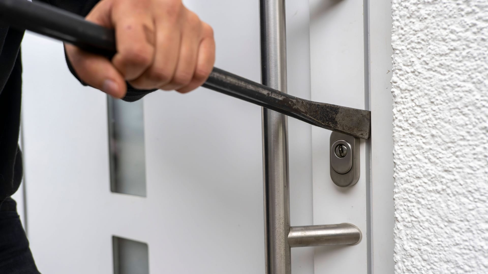 Ein Einbrecher versucht mit Brecheisen die Haustüre aufzubrechen (Symbolbild): In Gelsenkirchen erbeuteten Diebe Gegenstände im Wert von einer Milion Euro. Ein Einbrecher versucht mit Brecheisen die Haustüre aufzubrechen (Symbolbild): In Gelsenkirchen erbeuteten Diebe Gegenstände im Wert von einer Milion Euro.