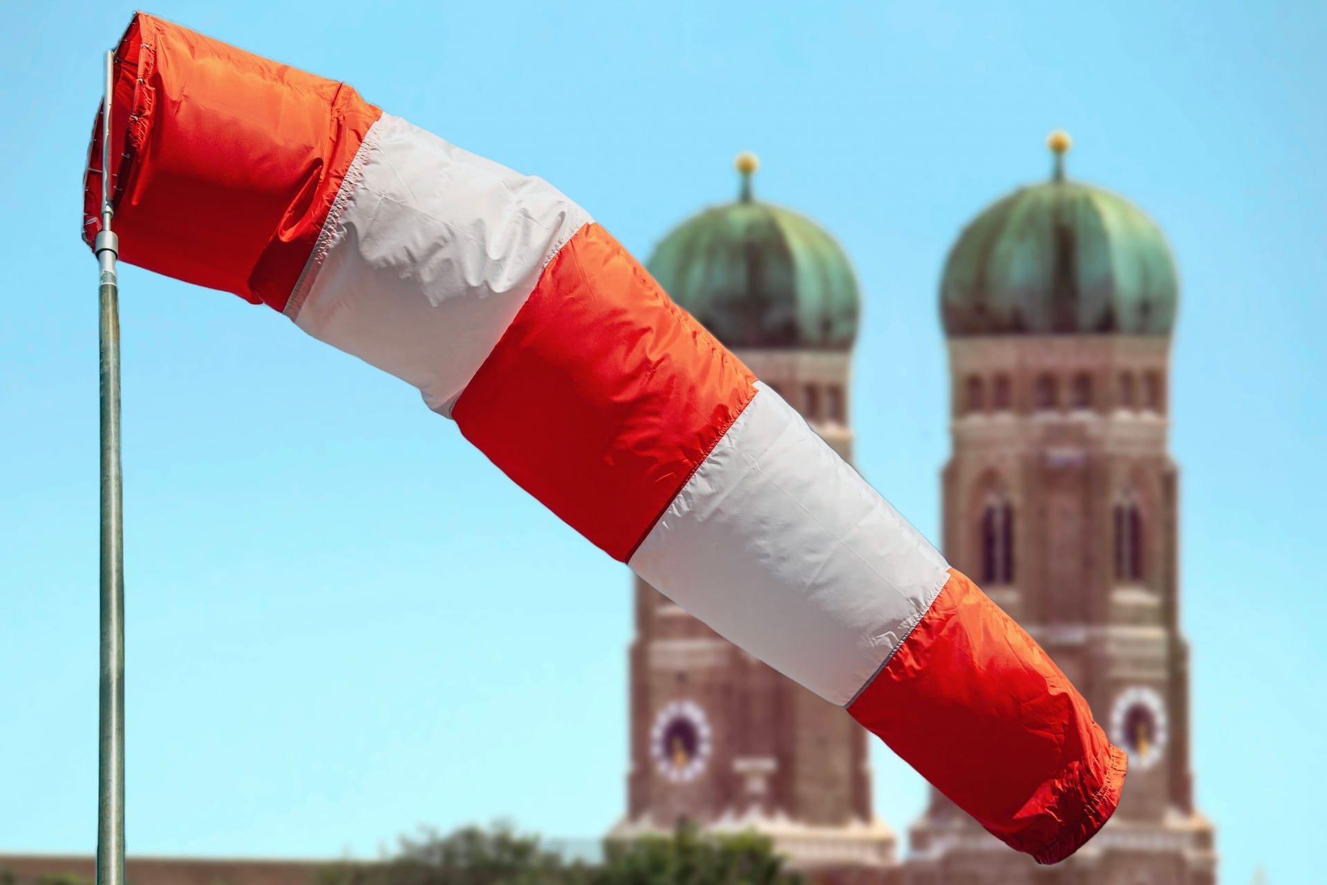 Eine Windhose vor den Türmen der Frauenkirche in München (Symbolbild): Am Wochenende erwartet man in Bayern teils Sturm.