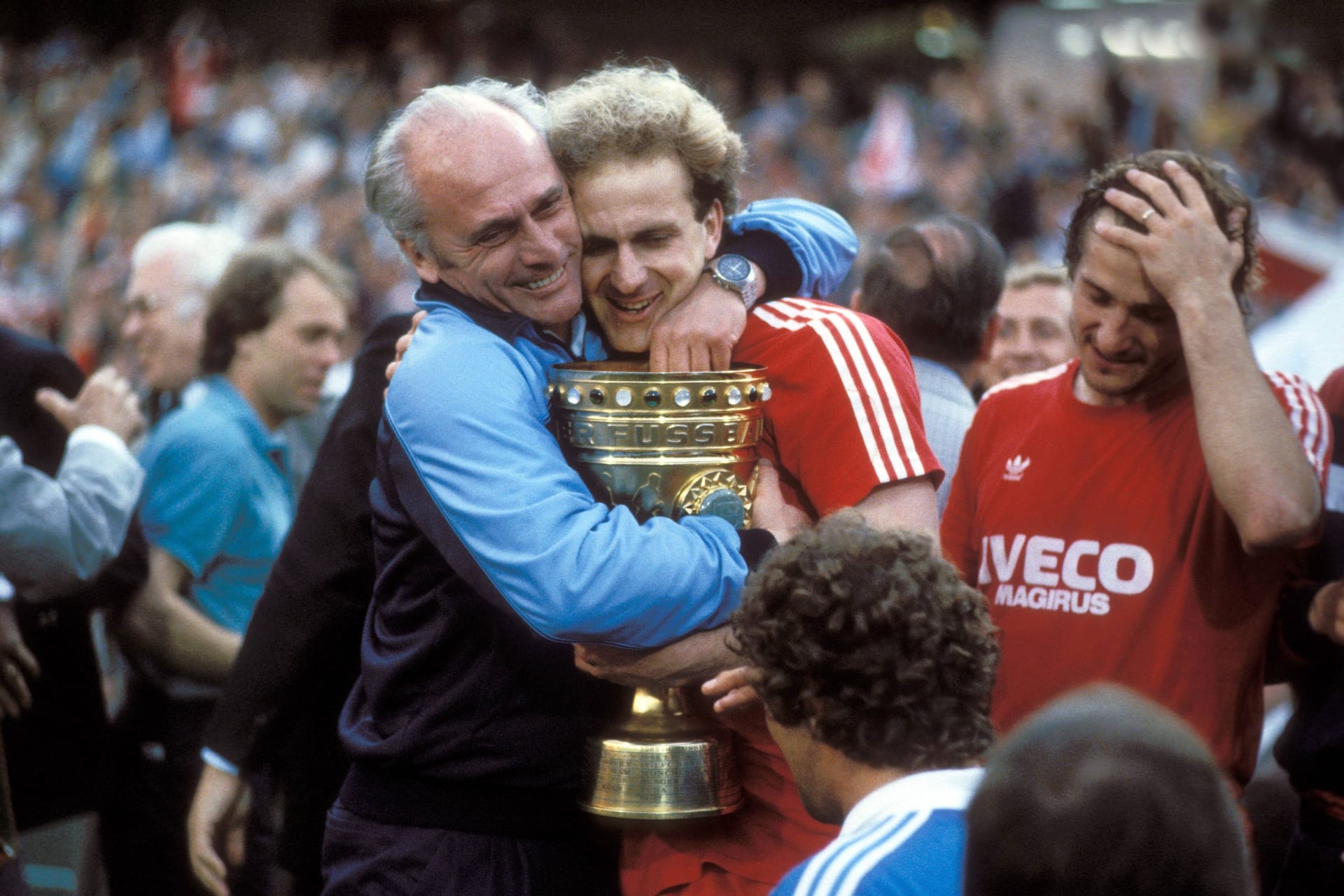 Pokalsieg im letzten Spiel für die Bayern: Am 31.05.1984 verabschiedet sich Rummenigge nach dem Erfolg gegen Borussia Mönchengladbach (8:7 n.E.) aus München. Zum Abschied wird er von Trainer Udo Lattek geherzt.