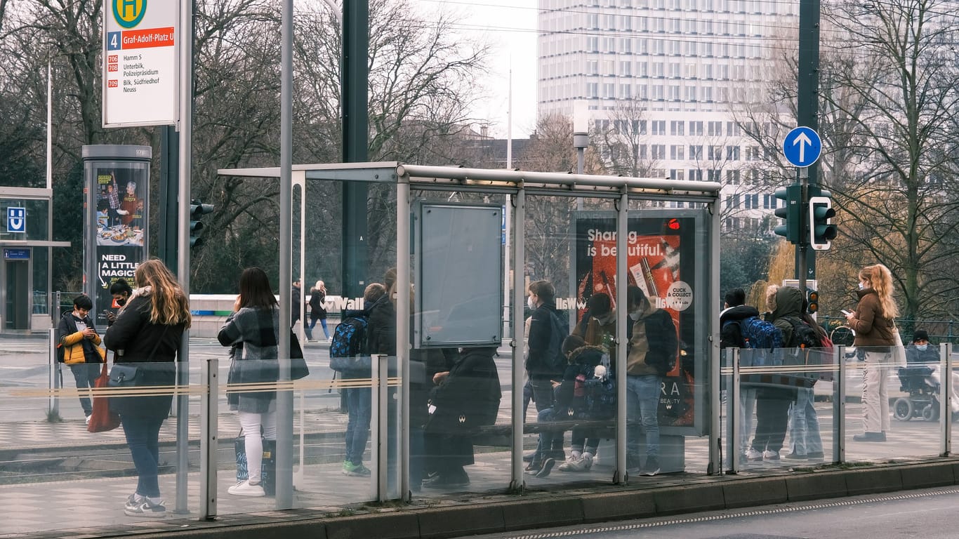 Kinder stehen an einer Bus-Haltestelle in Düsseldorf (Symbolbild): Warum der Junge plötzlich auf die Fahrbahn stürzte, ist noch unklar.