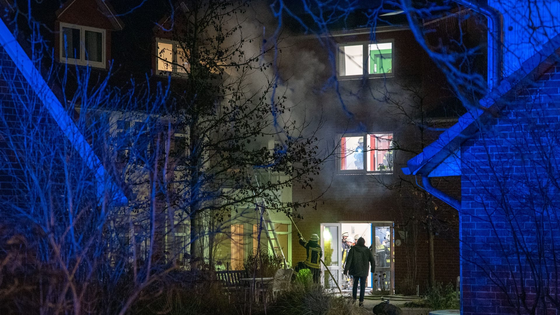 Einsatzkräfte löschen die Flammen über ein Fenster: Warum das Feuer ausbrach, ist noch unklar. Einsatzkräfte löschen die Flammen über ein Fenster: Warum das Feuer ausbrach, ist noch unklar.