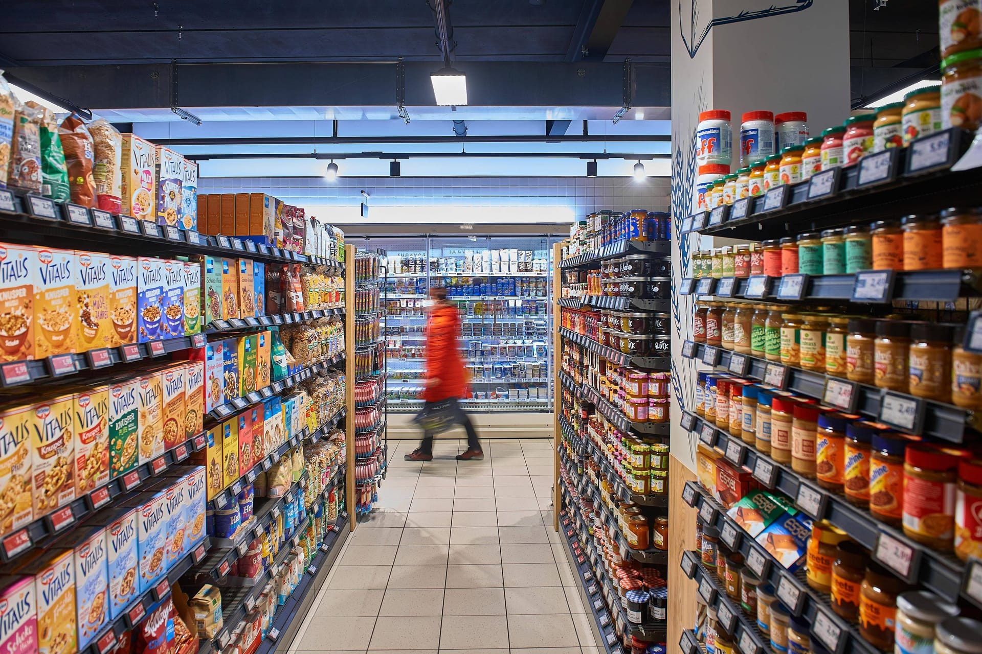 Person bei Edeka (Symbolbild): Kunden greifen angesichts der steigenden Preise tendenziell eher zur günstigeren Eigenmarke als zum Markenartikel.