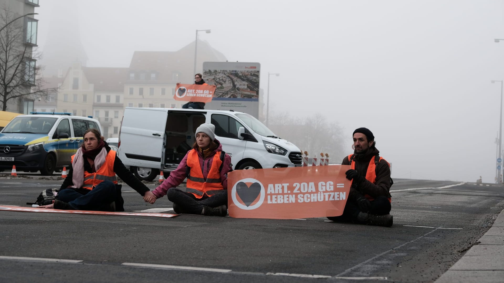 Blockade in Berlin: Raphael Thelen sitzt außen auf der Straße.