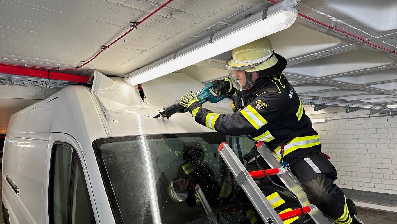 Ein Feuerwehrmann muss das Dach aufschneiden, um den Wagen wieder zu "befreien".