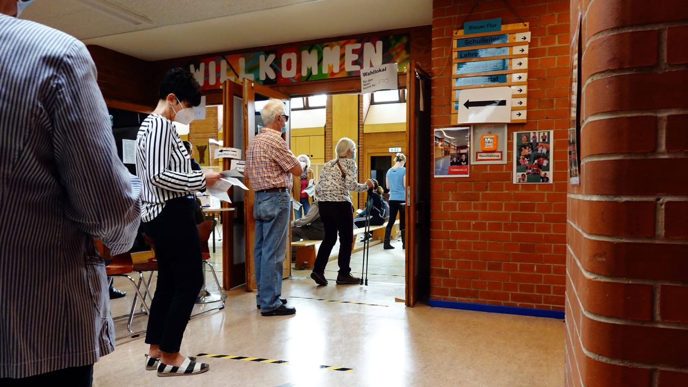 Menschen stehen vor einem Wahllokal in einer Schule an (Archivbild): Die Wiederholungswahl steht kurz bevor.