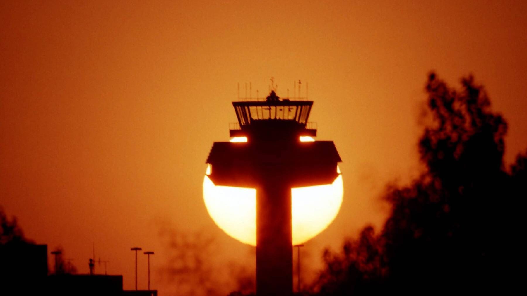 Die Sonne geht hinter dem Tower des Flughafens in Hannover-Langenhagen unter (Archivbild): Unbekannte sollen am Montagabend versucht haben, die Fluglotsen zu stören.