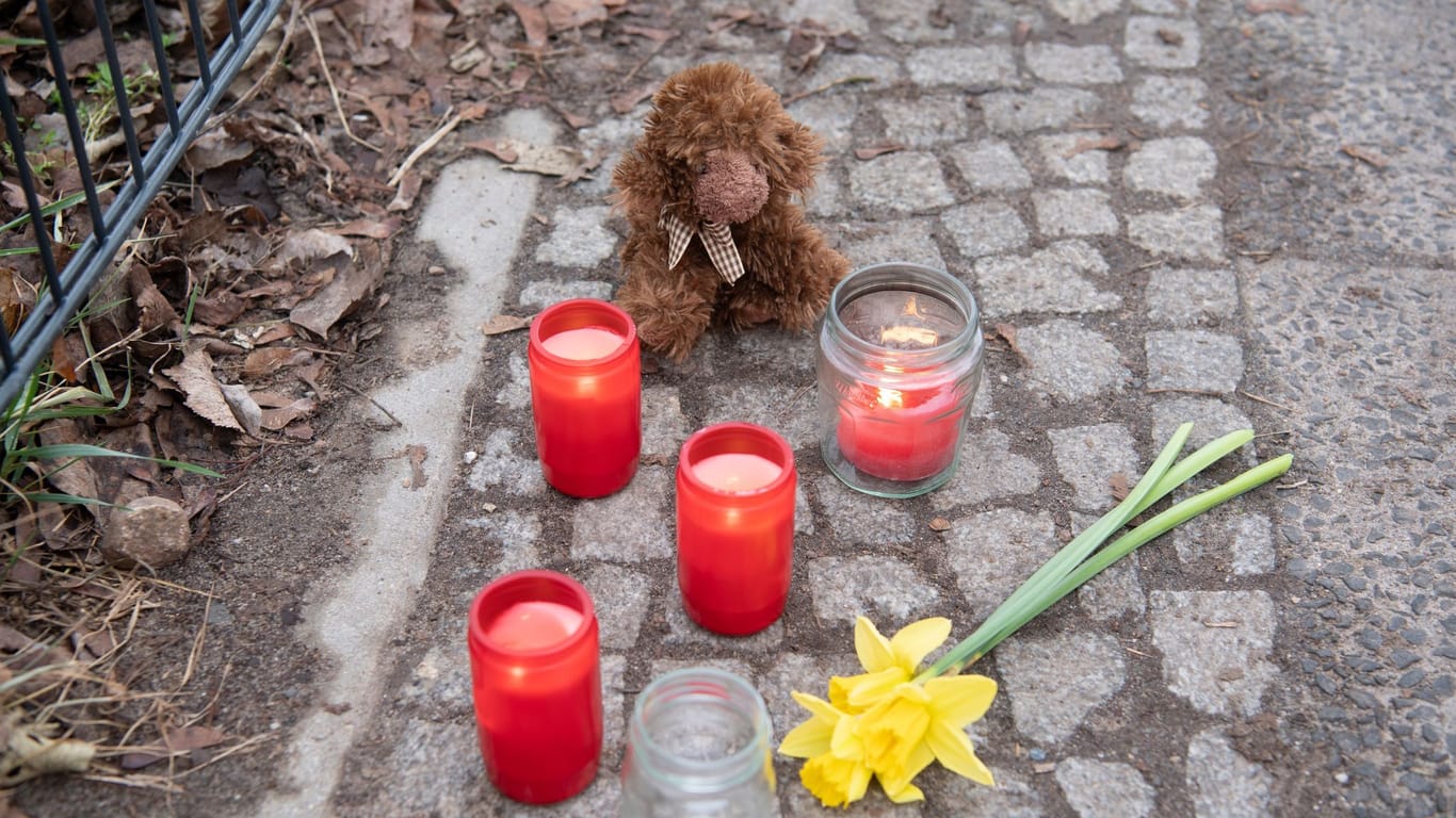 Kerzen und Blumen stehen unweit des Tatortes: Nach dem Tod eines Kindes werden neue Details bekannt.
