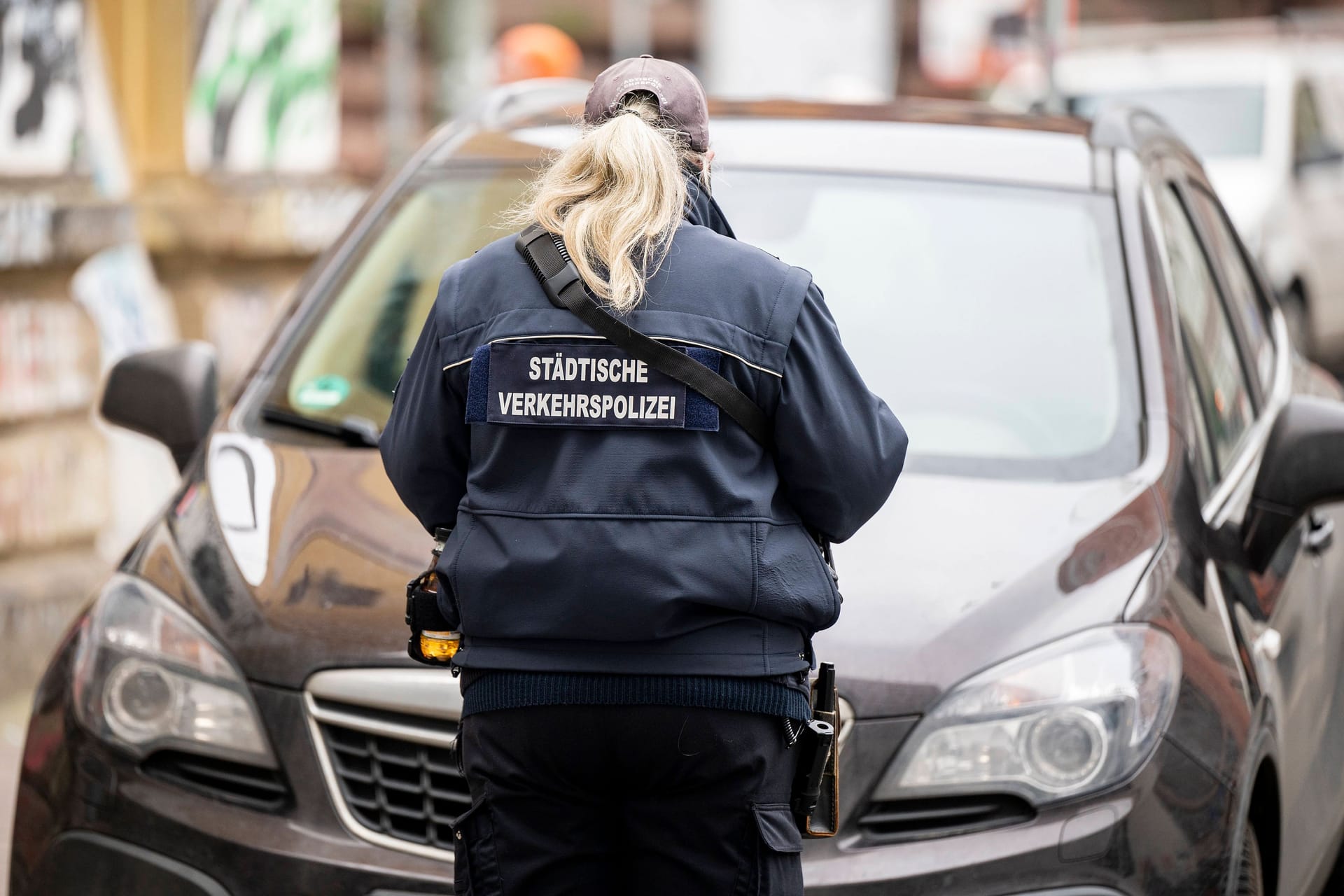 Eine Mitarbeiterin der Städtischen Verkehrspolizei in Frankfurt schreibt einen Strafzettel (Symbolbild): Ein Rettungswagen brachte den Falschparker in die Klinik.