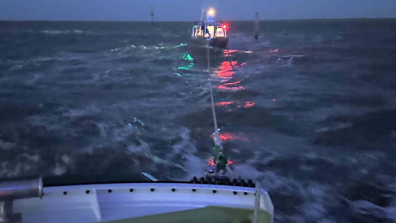 Ein Seenotrettungsboot schleppt die Inselfähre vor Ostfriesland ab.