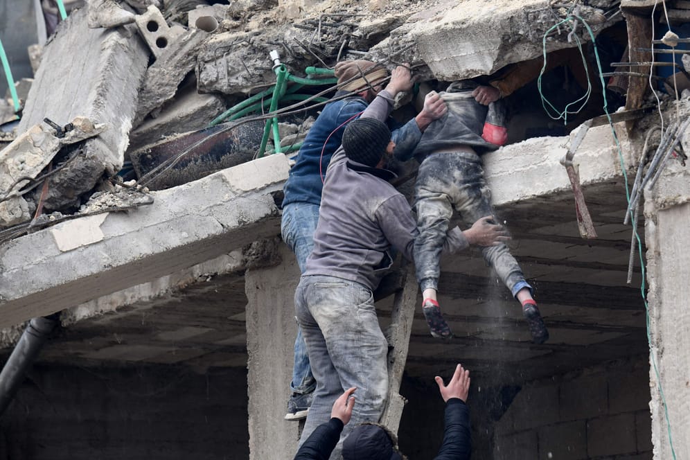 In der Stadt Jandaris, im Nordwesten Syriens, bergen Menschen ein Opfer des Erdbebens aus den Trümmern eines eingestürzten Hauses.