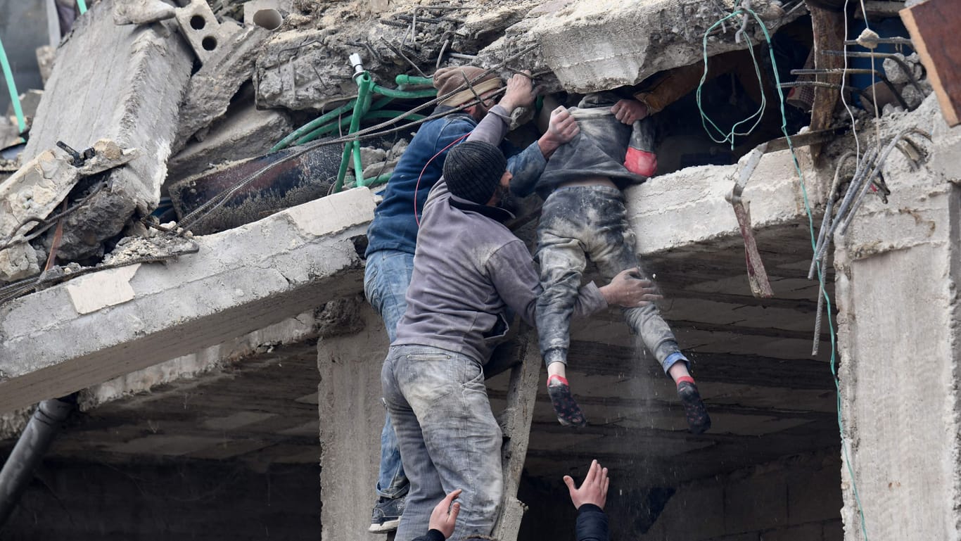 In der Stadt Jandaris, im Nordwesten Syriens, bergen Menschen ein Opfer des Erdbebens aus den Trümmern eines eingestürzten Hauses.