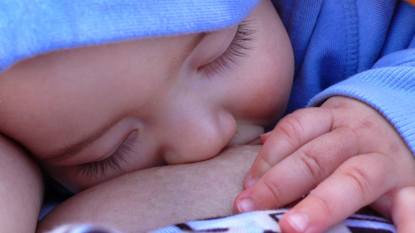 Ein Baby ist beim Stillen eingeschlafen: Selbst im Blut der Kleinsten lassen sich schon PFAS nachweisen.