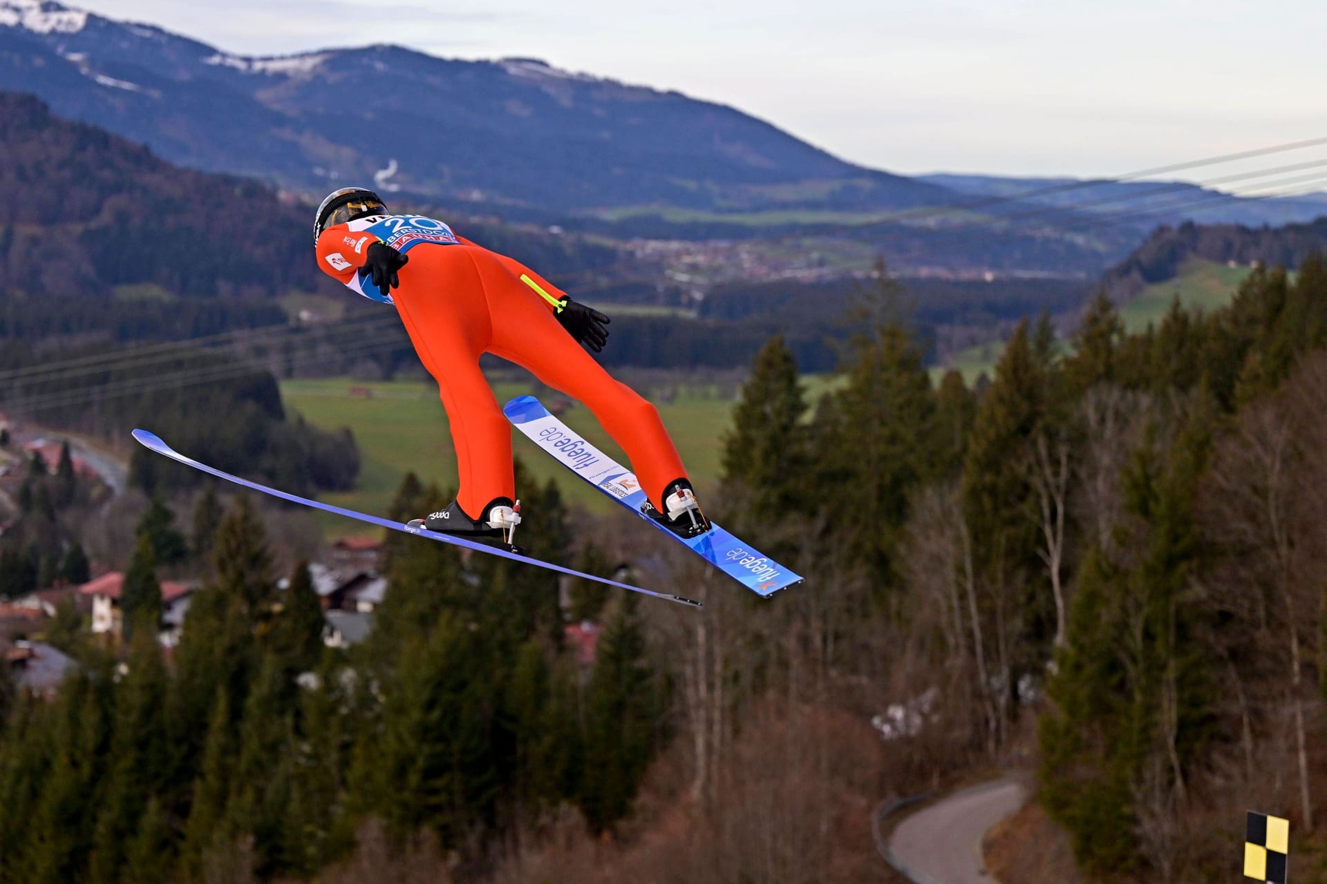 Ein Skispringer in der Luft: Immer häufiger blicken die Athleten bei ihren Flügen ins Grüne statt in eine Winterlandschaft.