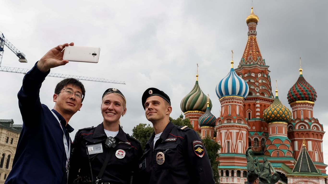 Polizisten posieren mit einem Touristen in Moskau (Archivbild): Der Tourismus ist seit dem russischen Angriffskrieg deutlich zurückgegangen.
