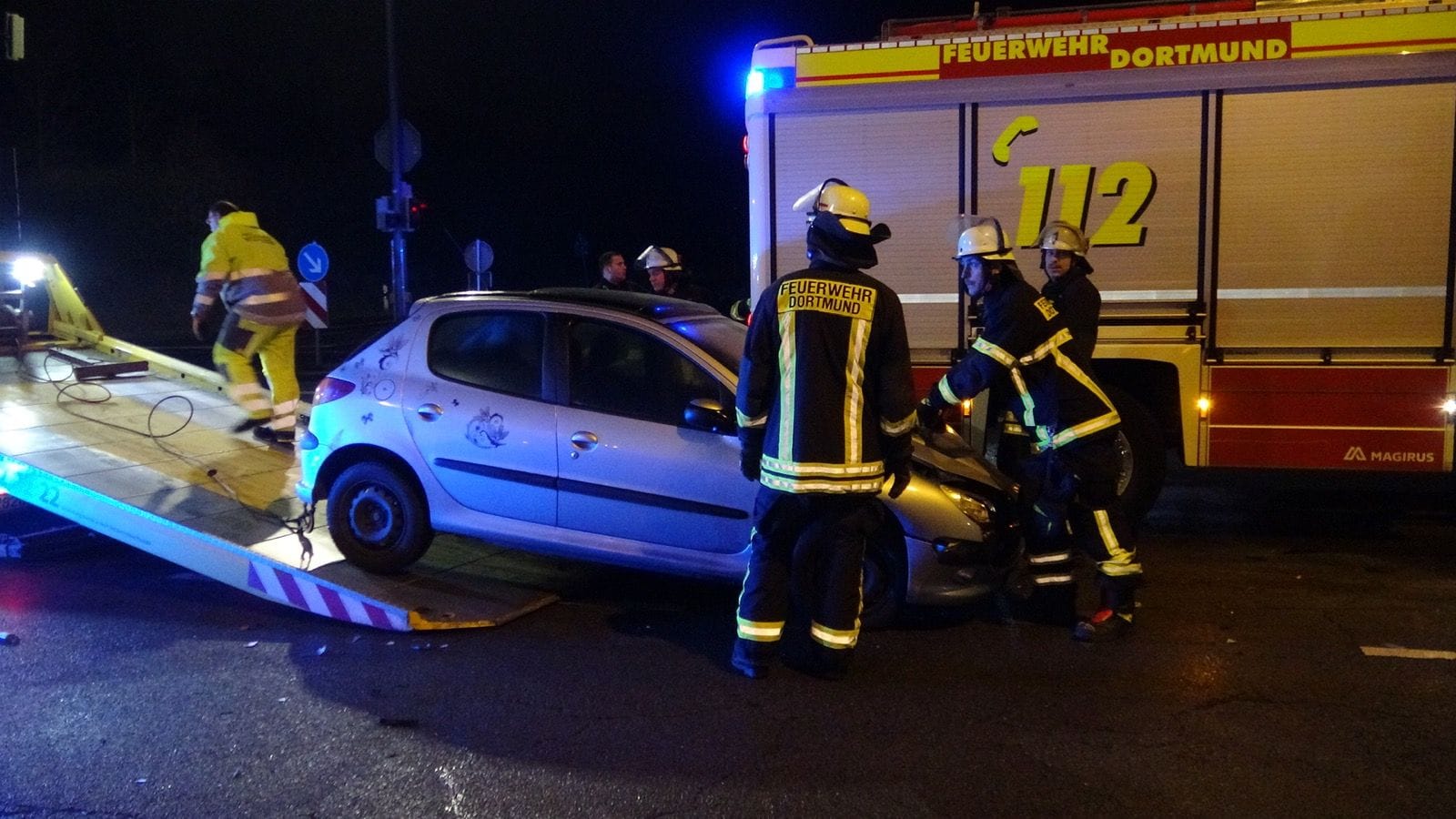 Einsatzkräfte der Feuerwehr helfen nach dem Unfall mit: Zuvor war ein Einsatzwagen mit einem Kleinwagen zusammengestoßen. Einsatzkräfte der Feuerwehr helfen nach dem Unfall mit: Zuvor war ein Einsatzwagen mit einem Kleinwagen zusammengestoßen.
