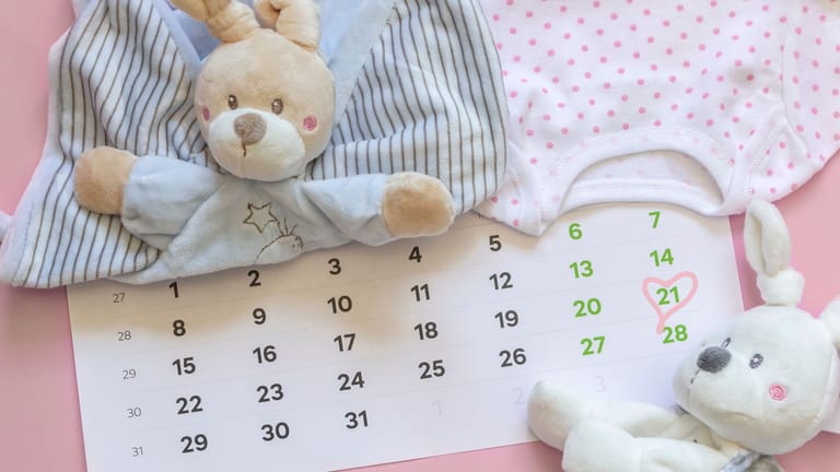 Ein Kalenderblatt mit markiertem Datum, umgeben von Babyspielzeug