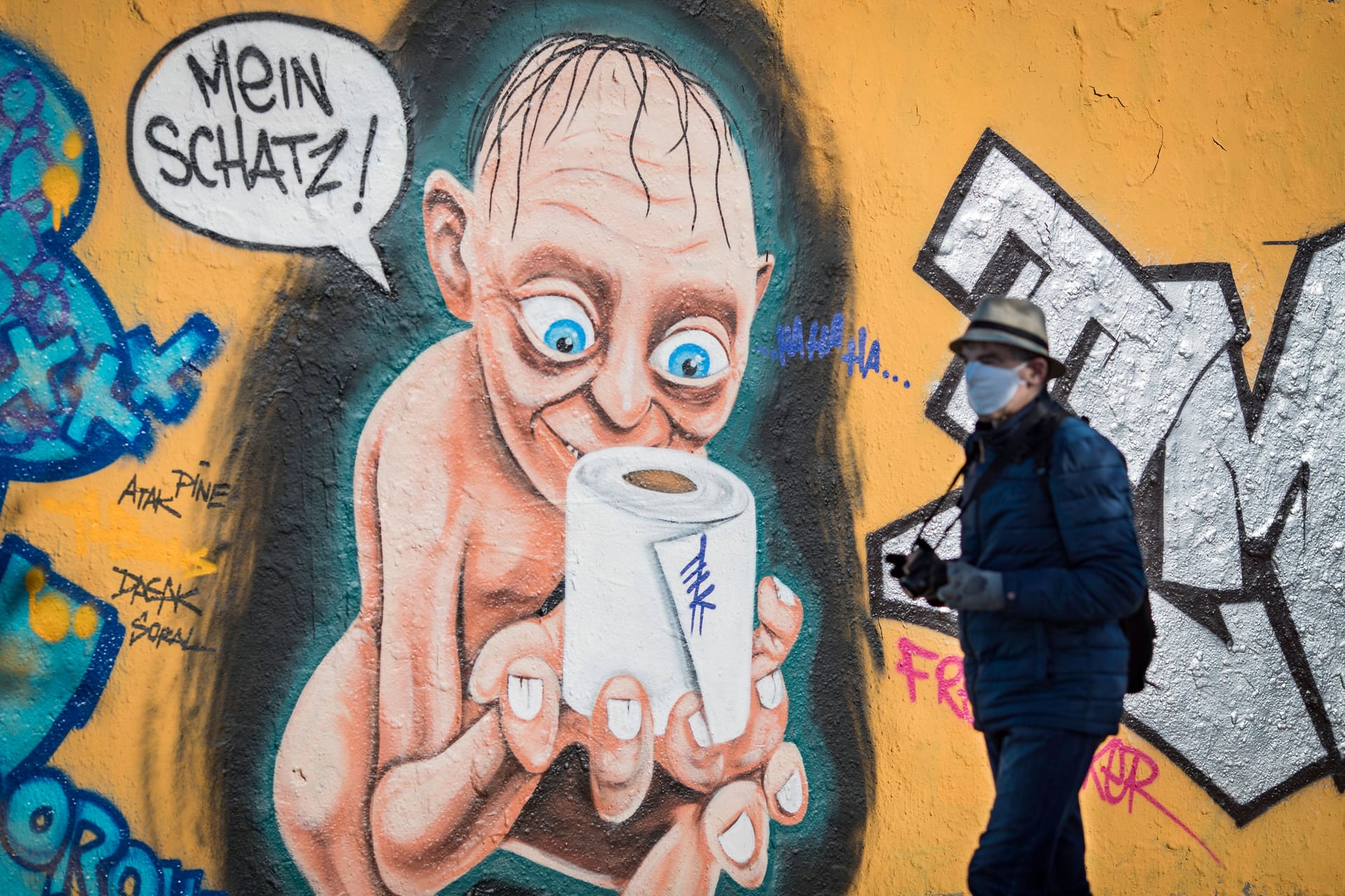 Mann mit Maske vor Graffiti in Berlin: Damals gab es aber auch noch ganz andere Probleme.