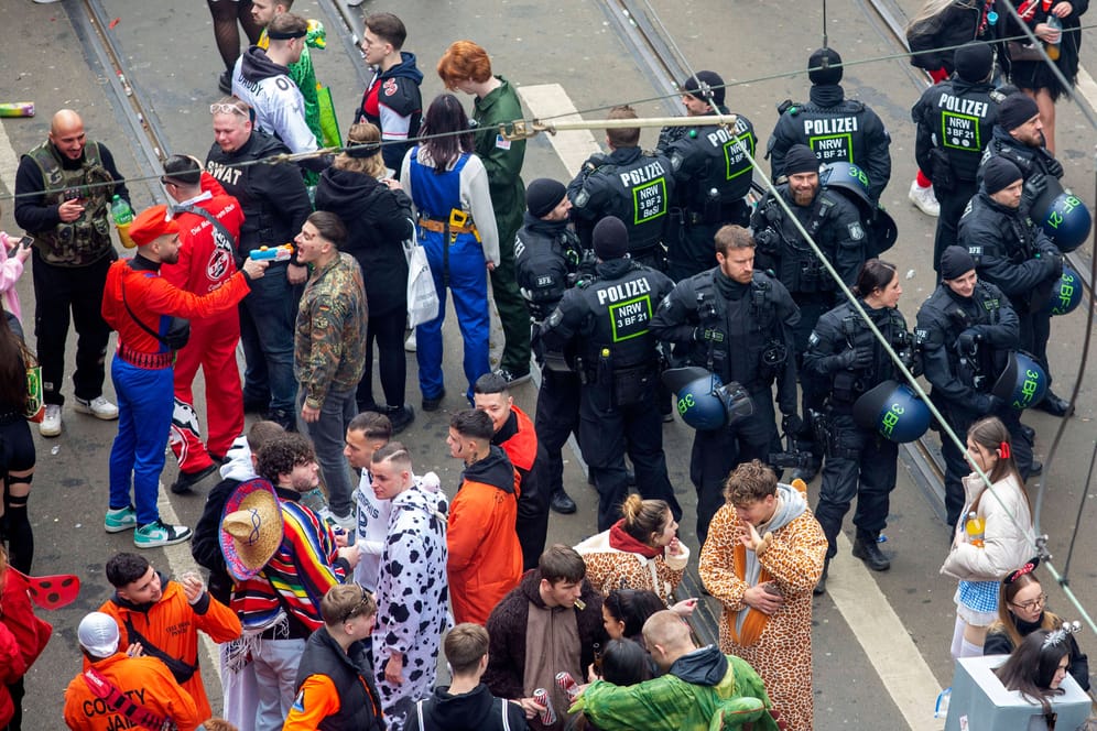Junge Karnevalisten feiern Weiberfastnacht auf der Zülpicher Straße in Köln: Die Polizei beobachtet das Geschehen.