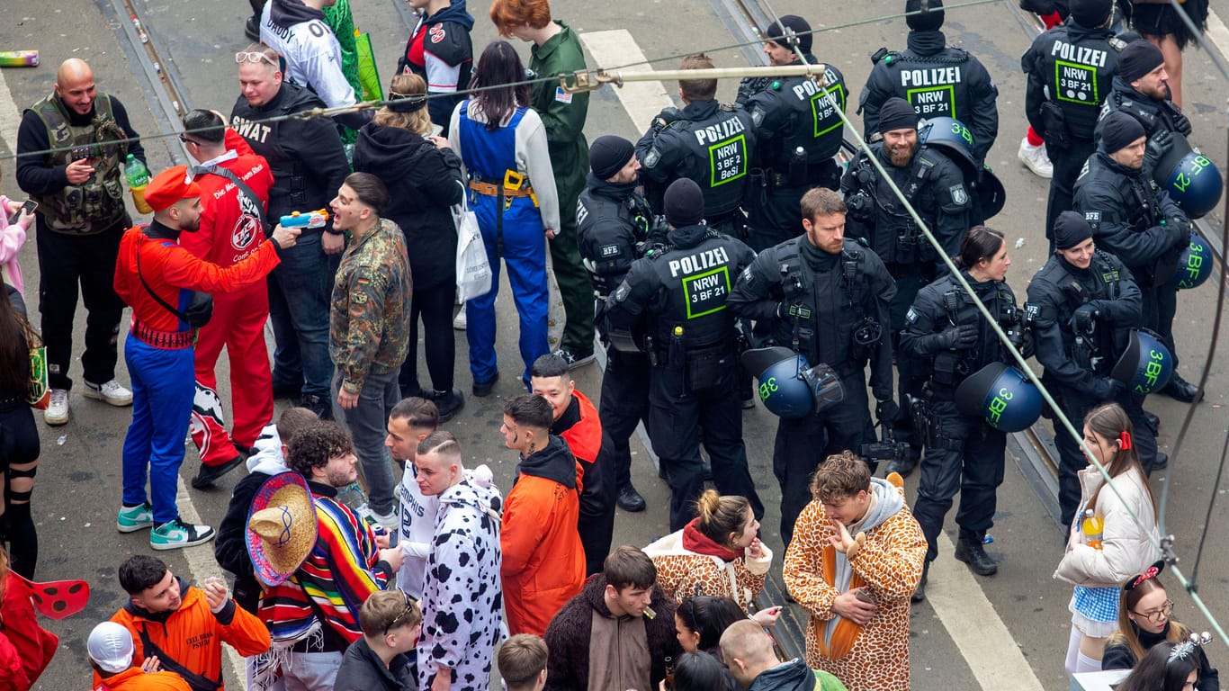 Junge Karnevalisten feiern Weiberfastnacht auf der Zülpicher Straße in Köln: Die Polizei beobachtet das Geschehen.