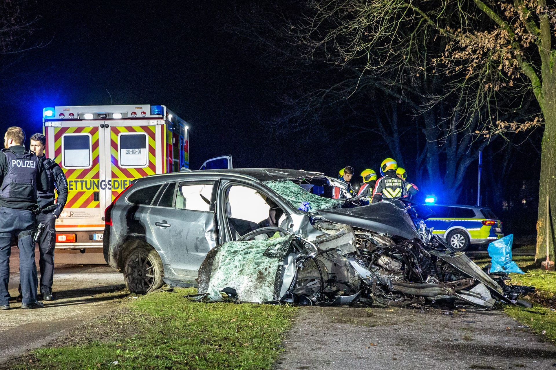 Einsatzkräfte stehen nehmen dem völlig zerstörten Pkw: Für den Fahrer kam jede Hilfe zu spät.