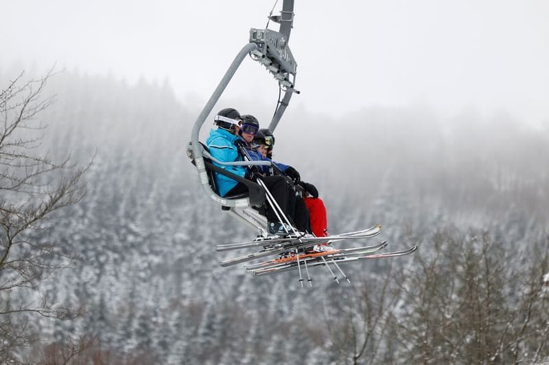 Skifahrer sitzen bei winterlichem Wetter in einem Sessellift in Winterberg im Sauerland (Archivbild).