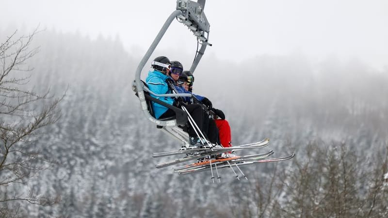 Skifahrer sitzen bei winterlichem Wetter in einem Sessellift in Winterberg im Sauerland (Archivbild).