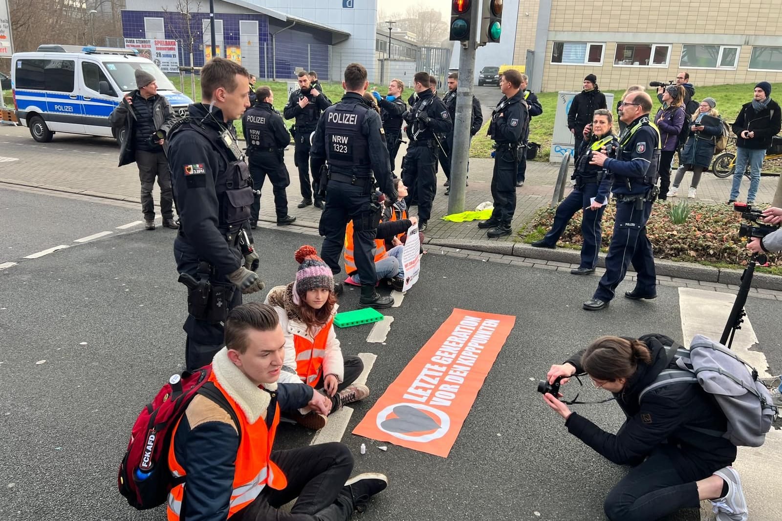 Fünf Aktivisten der Letzten Generation auf der zweispurigen Straße: Sie haben sich festgeklebt.