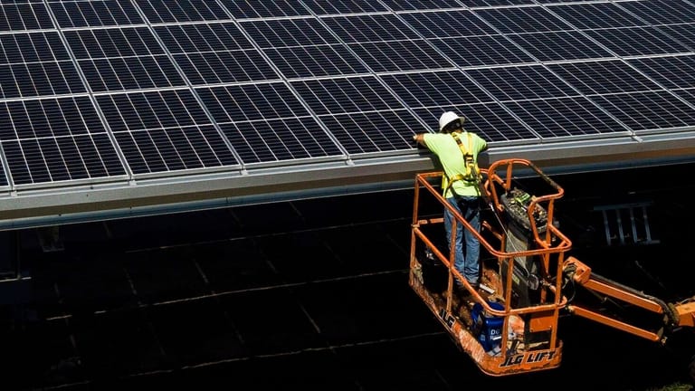 Ein Mitarbeiter einer Solarfirma installiert Sonnenkollektoren an der John Hopkins Middle School in Brandon, Florida. In den USA betreiben mehr als 8.000 Schulen eigene Solaranlagen.