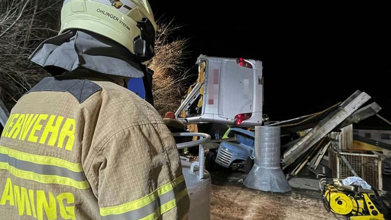 Rettungskräfte der Feuerwehr sind am Unglücksort im Einsatz: Ein deutscher Reisebus ist bei Schladming über eine Böschung gestürzt.