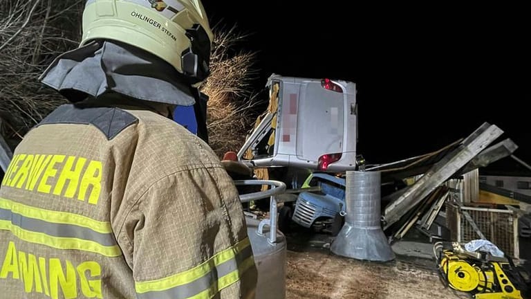 Rettungskräfte der Feuerwehr sind am Unglücksort im Einsatz: Ein deutscher Reisebus ist bei Schladming über eine Böschung gestürzt.
