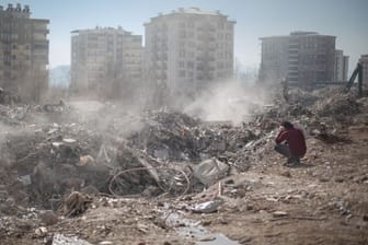 Ein Mann sitzt neben seinem eingestürzten Haus in Kharamanmaras: Das Beben hat in der Türkei mindestens 105.000 Gebäude vollständig oder teilweise zerstört.