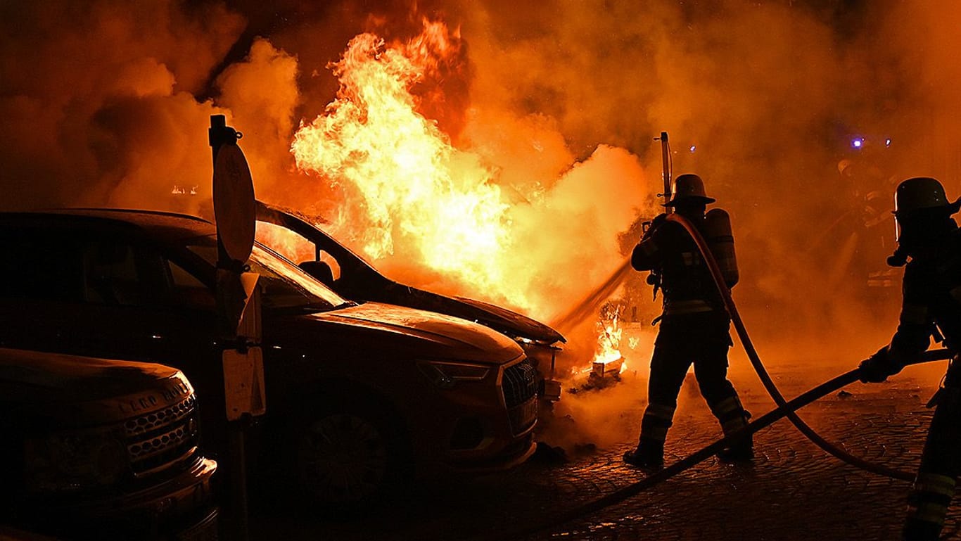 Der Wagen steht in Flammen: Die Feuerwehr kann ein Übergreifen des Brandes auf andere Autos und ein Gebäude verhindern.