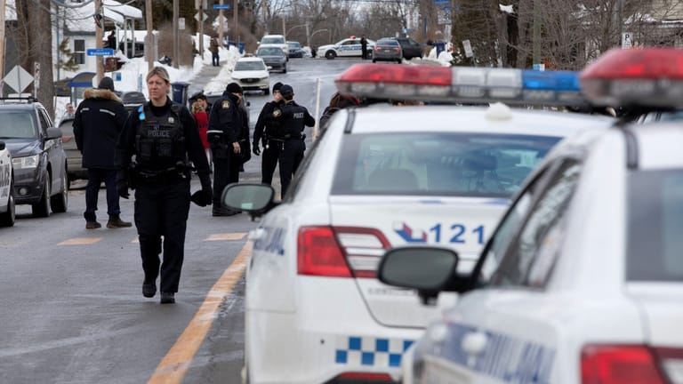 Laval police vehicles mark a road block along Dufferin Terrace