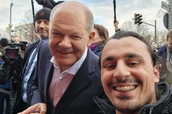 Olaf Scholz (SPD) mit dem Hannoveraner Ahmad Zataar: Journalisten ließ der Kanzler stehen – aber für Fotos mit Passanten nahm er sich Zeit.