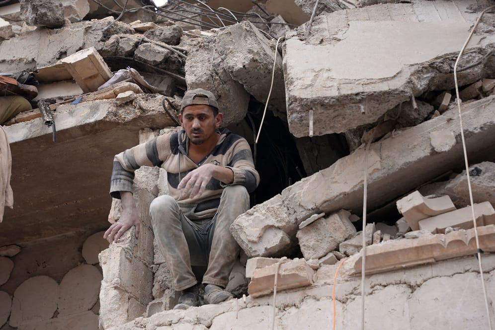 Erdbeben in der Türkei und Syrien: Ein Mann sitzt in den Trümmern eines Hauses in der nordsyrischen Stadt Cindirês.