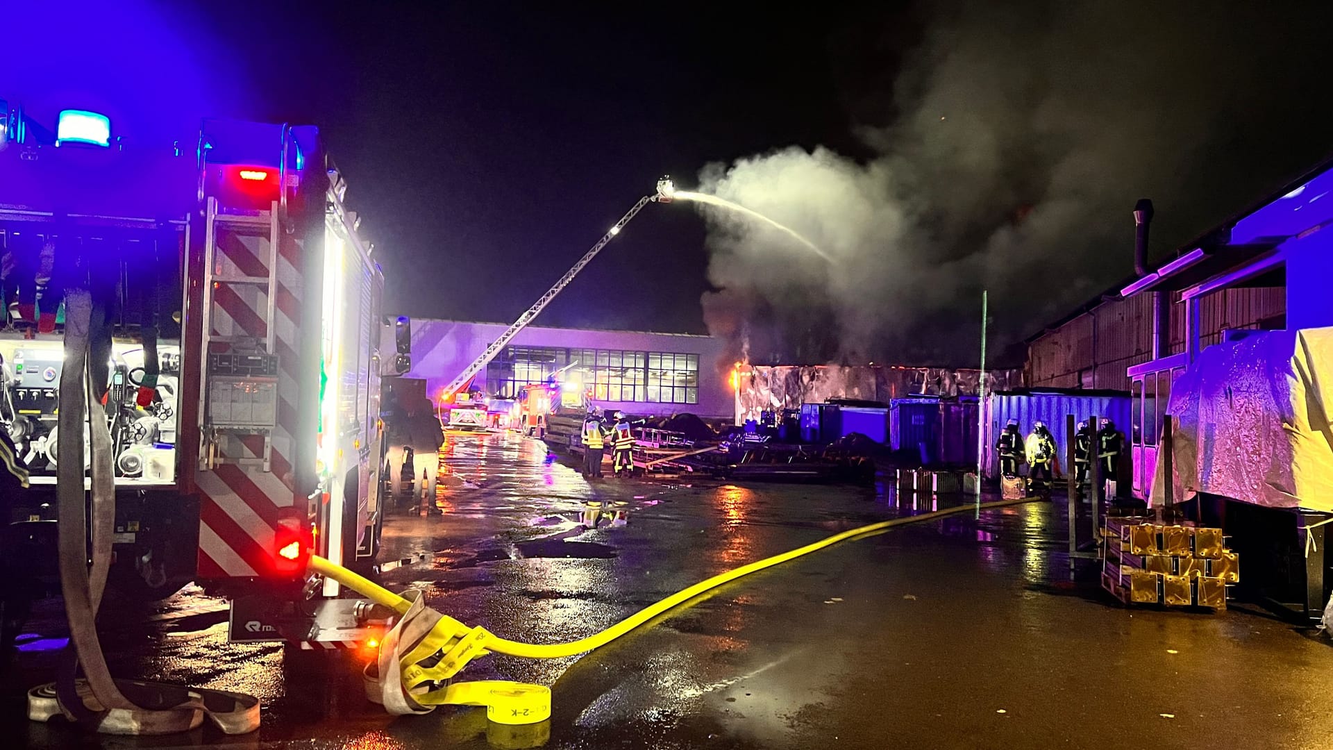 Feuerwehrleute stehen zusammen, um den Einsatz zu besprechen: Eine Lagerhalle stand am Mittwoch in Flammen. Feuerwehrleute stehen zusammen, um den Einsatz zu besprechen: Eine Lagerhalle stand am Mittwoch in Flammen.