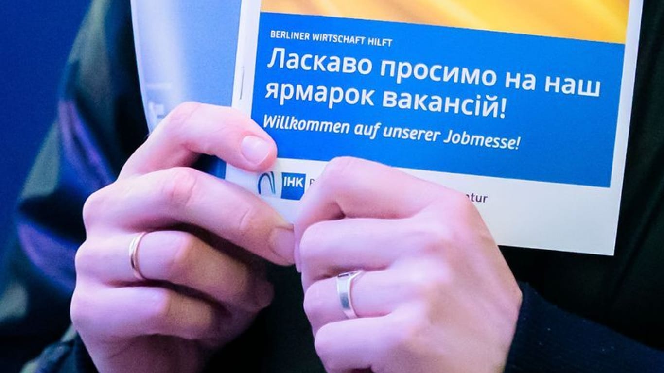 Frau mit Broschüre in ukrainischer Sprache einer Jobmesse: Die Zahl der Beschäftigten aus der Ukraine wird wohl in den nächsten Wochen und Monaten deutlich steigen.